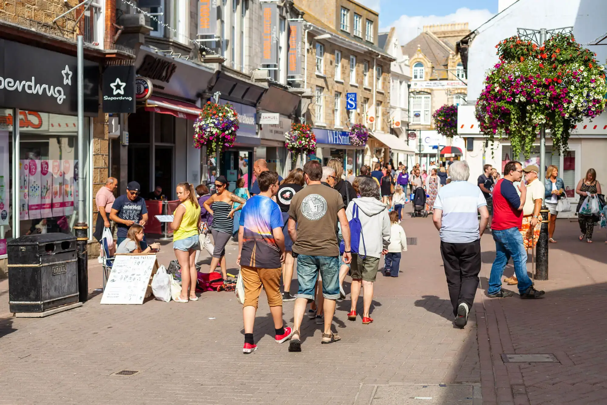 The busy Newquay high street, with shops and shoppers on a sunny day